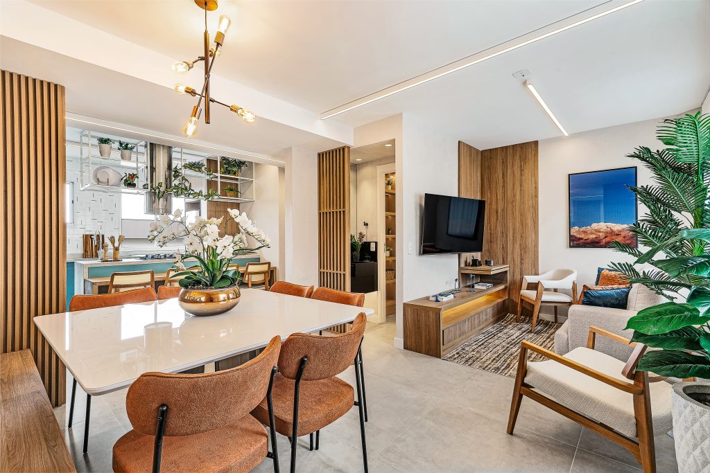 Sala integrada planejada Casa & Art com mesa de jantar moderna, painel de TV em madeira e design sofisticado